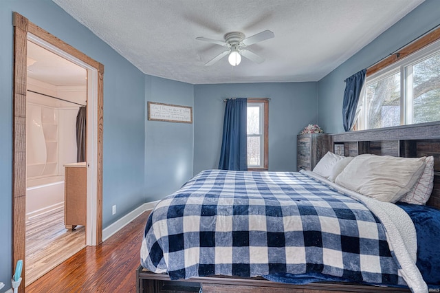 bedroom featuring dark wood-style floors, a textured ceiling, a ceiling fan, and baseboards