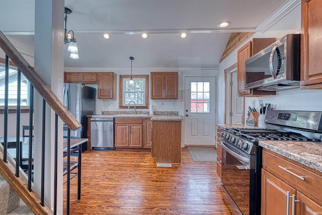 kitchen featuring appliances with stainless steel finishes, brown cabinetry, dark wood finished floors, and a sink