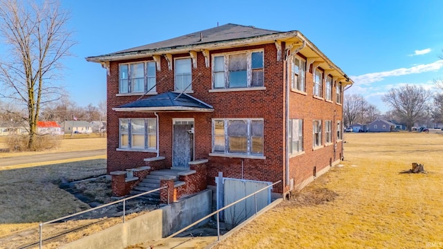 view of front of property with brick siding and a front lawn