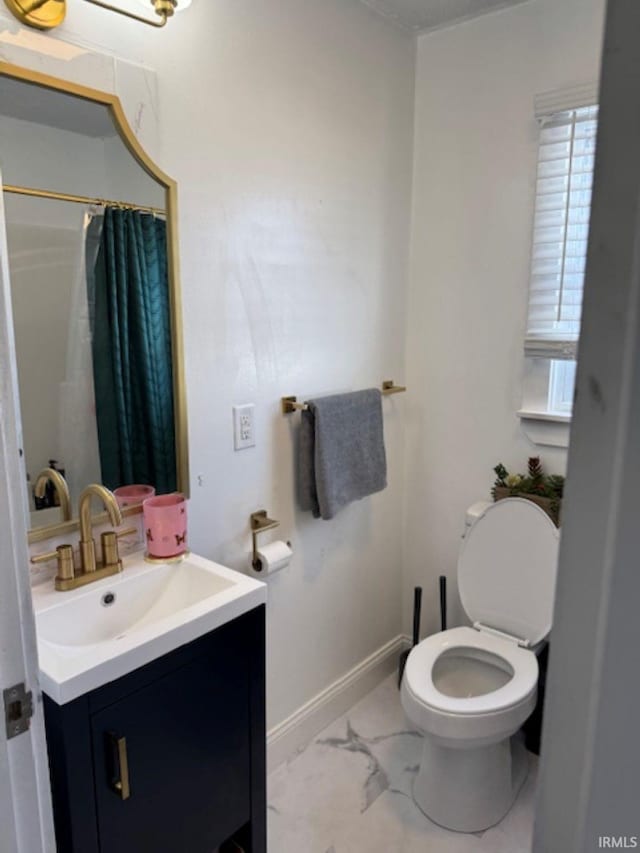 full bath with marble finish floor, toilet, vanity, a shower with curtain, and baseboards