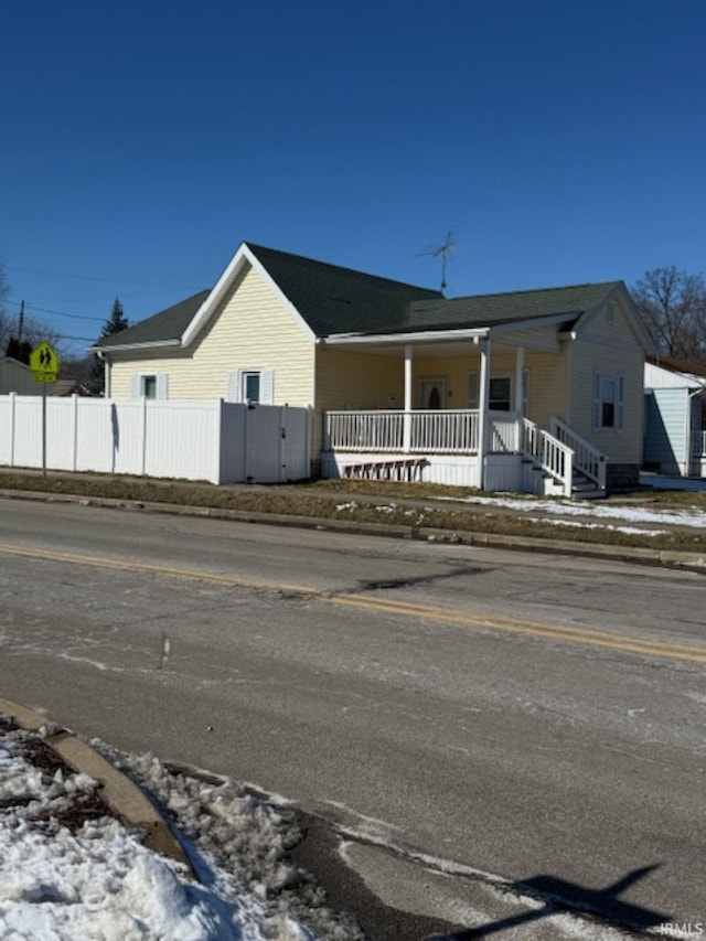 view of front of house featuring a porch and fence