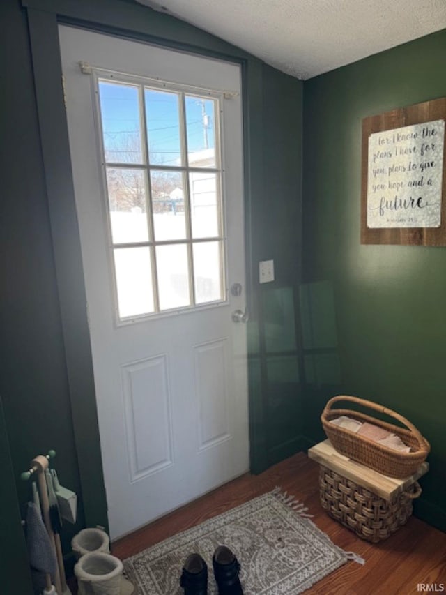 doorway with a textured ceiling and wood finished floors