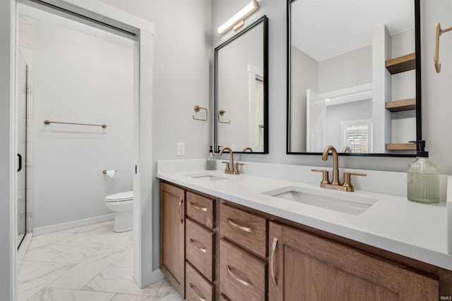 bathroom with marble finish floor, a sink, toilet, and double vanity