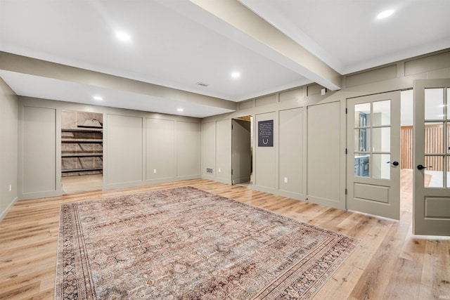 interior space featuring light wood finished floors, visible vents, a decorative wall, and recessed lighting