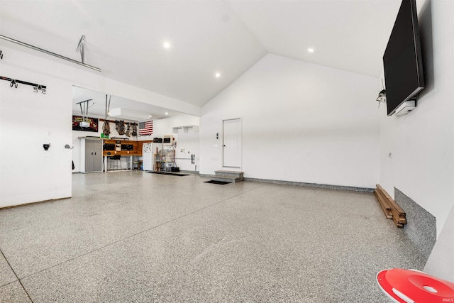 garage with freestanding refrigerator, baseboards, and recessed lighting