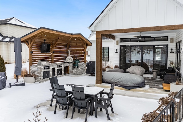 snow covered patio with a grill, outdoor dining area, and area for grilling