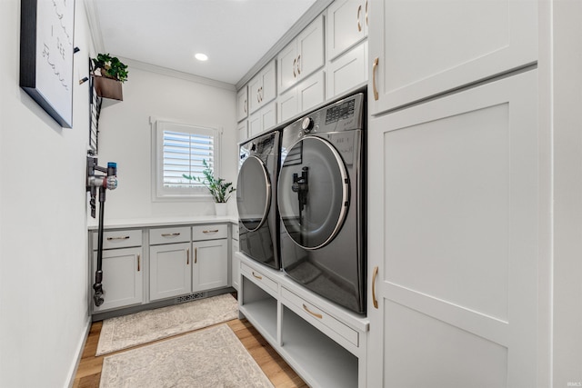 clothes washing area with crown molding, recessed lighting, cabinet space, separate washer and dryer, and light wood-type flooring