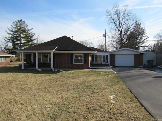 single story home featuring covered porch, driveway, brick siding, and a front lawn