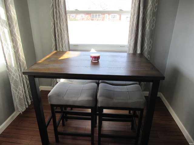 dining room with dark wood-type flooring and baseboards