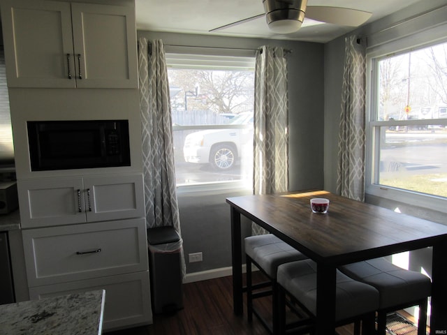 dining room featuring dark wood-style floors and a ceiling fan