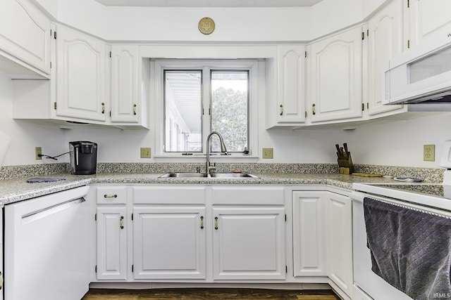 kitchen with white appliances, a sink, and white cabinetry