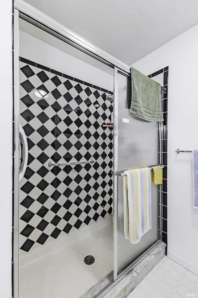 bathroom featuring a tile shower and a textured ceiling