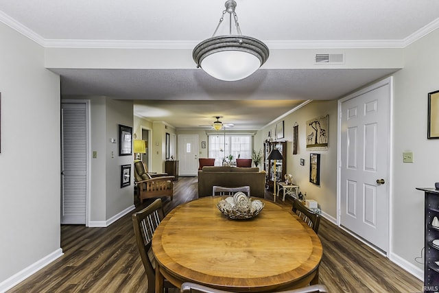 dining space with dark wood-style flooring, visible vents, and crown molding