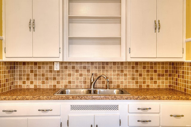 kitchen featuring a sink, white cabinetry, open shelves, tasteful backsplash, and dark countertops