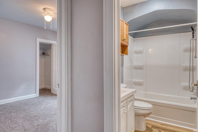 bathroom with baseboards, bathing tub / shower combination, toilet, and vanity