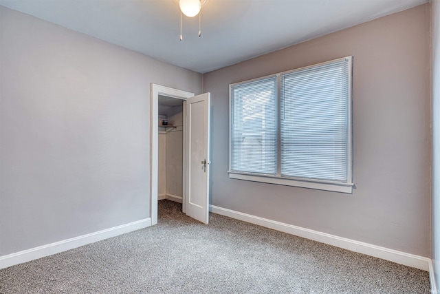 unfurnished bedroom with a ceiling fan, carpet, a closet, and baseboards