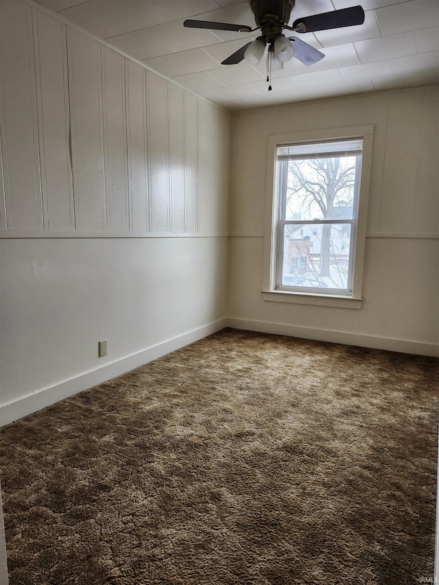 carpeted empty room with ceiling fan and baseboards