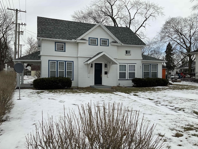 traditional home featuring roof with shingles