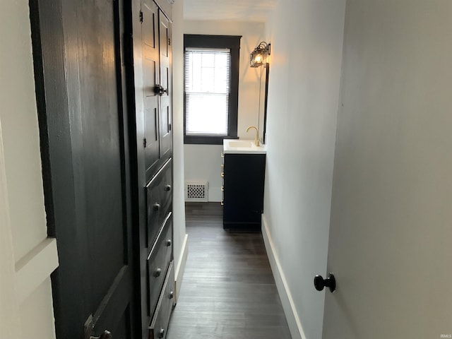 bathroom featuring baseboards, visible vents, wood finished floors, and vanity