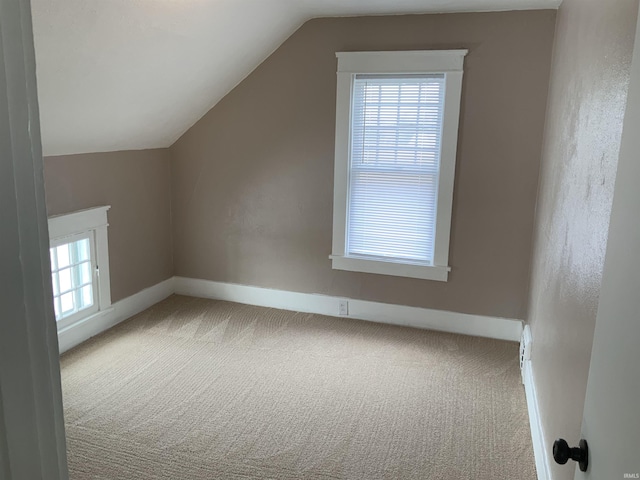 bonus room featuring lofted ceiling, carpet floors, and baseboards