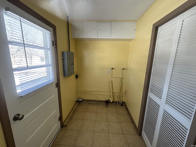 clothes washing area featuring electric panel and baseboards