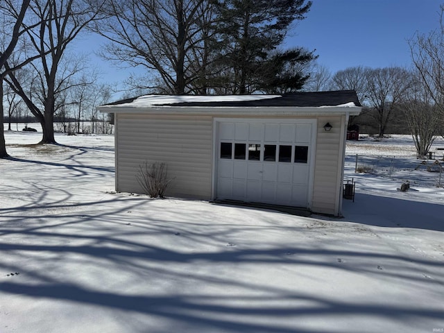 snow covered garage featuring a garage