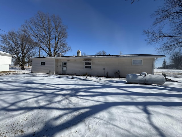 snow covered property with central AC unit