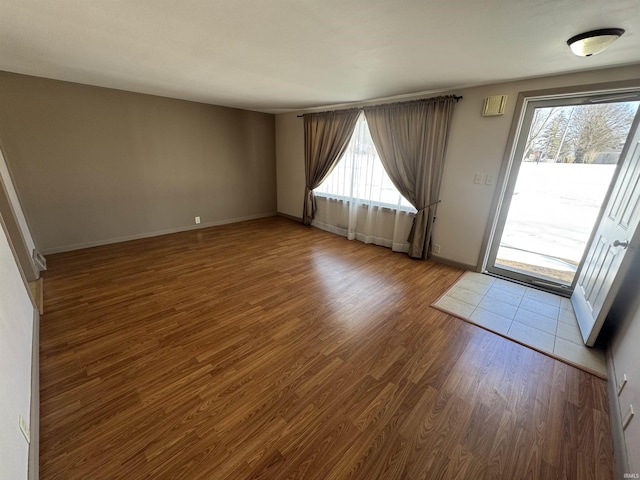 unfurnished room featuring baseboards and wood finished floors