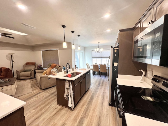 kitchen featuring light countertops, appliances with stainless steel finishes, a sink, and dark brown cabinetry