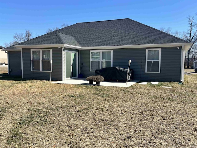 back of house with a patio area, a shingled roof, and a lawn