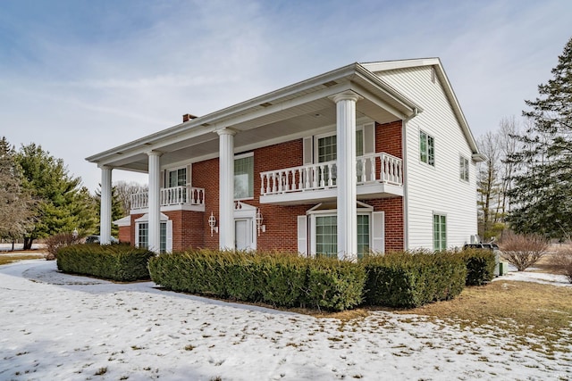 view of front facade with brick siding and a porch