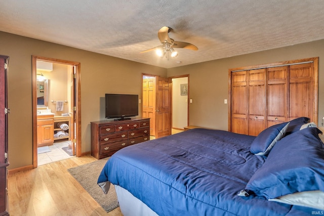 bedroom featuring a closet, light wood-style flooring, ceiling fan, a textured ceiling, and baseboards