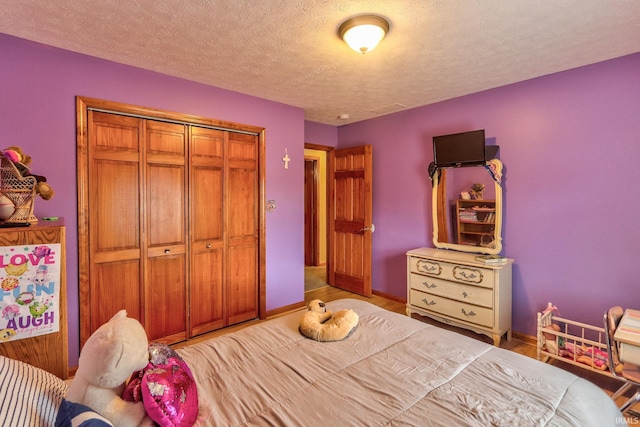 bedroom with a closet, baseboards, and a textured ceiling