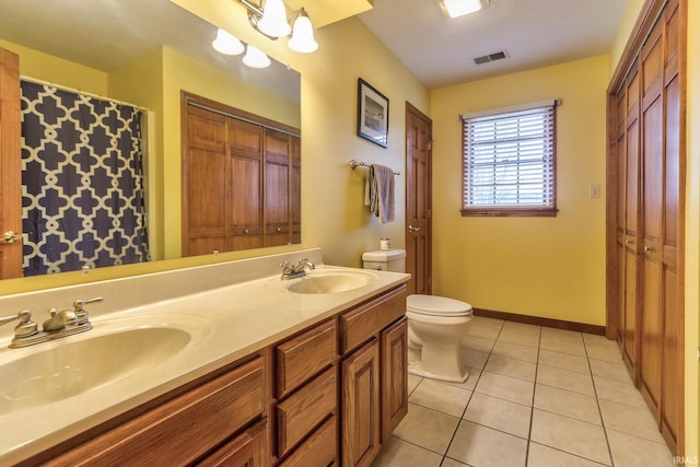 bathroom with a closet, visible vents, a sink, and tile patterned floors