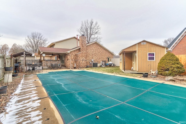 view of swimming pool with a fenced in pool, central AC unit, fence, exterior bar, and an outdoor structure