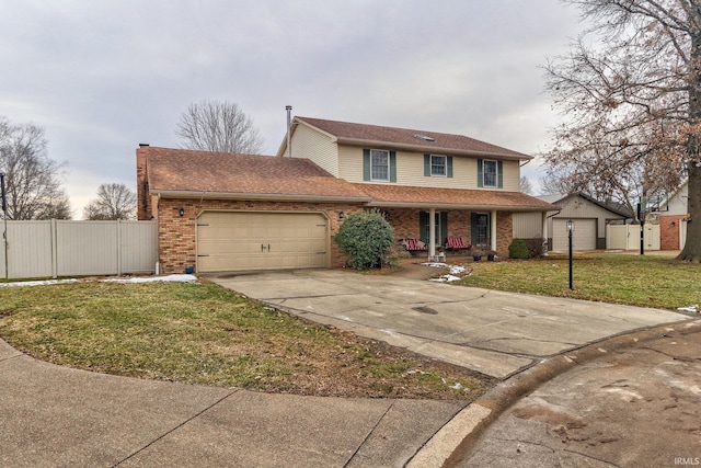 traditional home with a garage, brick siding, fence, concrete driveway, and a front yard