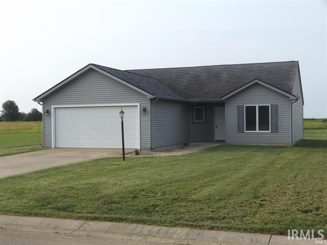 ranch-style house with a garage, driveway, and a front yard