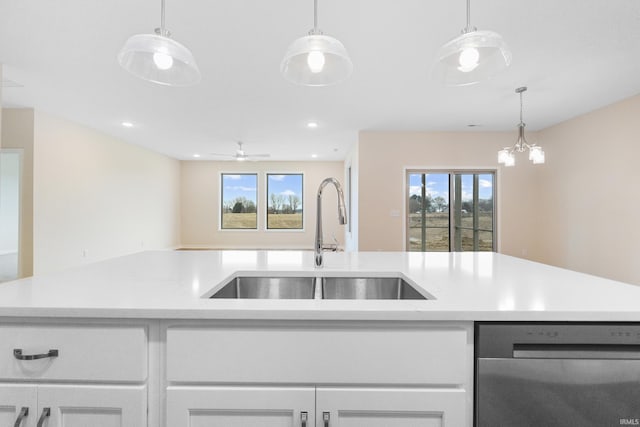 kitchen with dishwasher, open floor plan, a healthy amount of sunlight, white cabinetry, and a sink