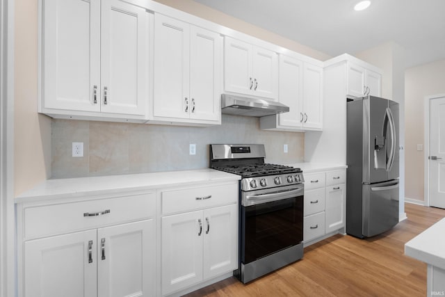 kitchen featuring under cabinet range hood, stainless steel appliances, white cabinets, light countertops, and light wood finished floors