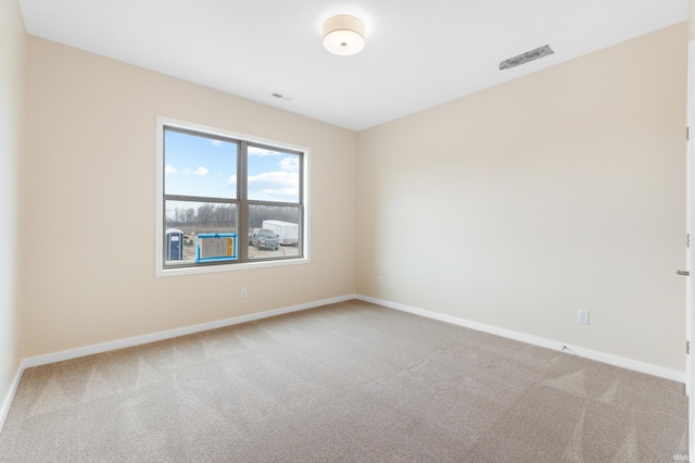 unfurnished room featuring carpet, visible vents, and baseboards