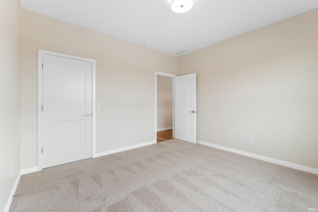 unfurnished bedroom featuring baseboards and light colored carpet