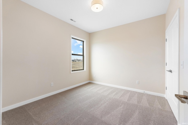 empty room featuring carpet, visible vents, and baseboards