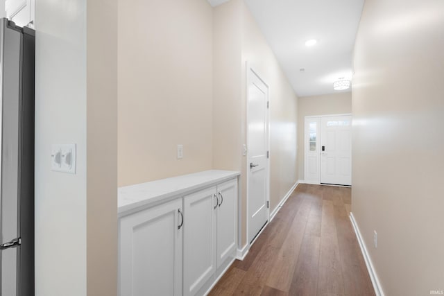 hall featuring recessed lighting, wood finished floors, and baseboards