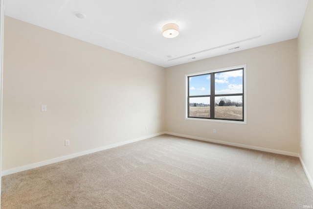 empty room with carpet floors, visible vents, and baseboards