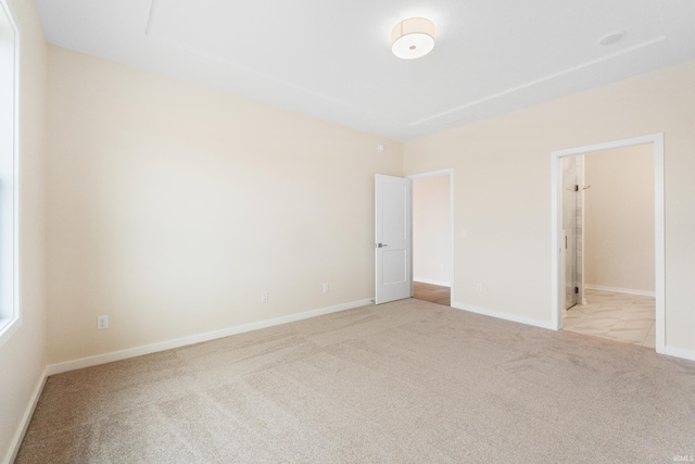 empty room with baseboards and light colored carpet