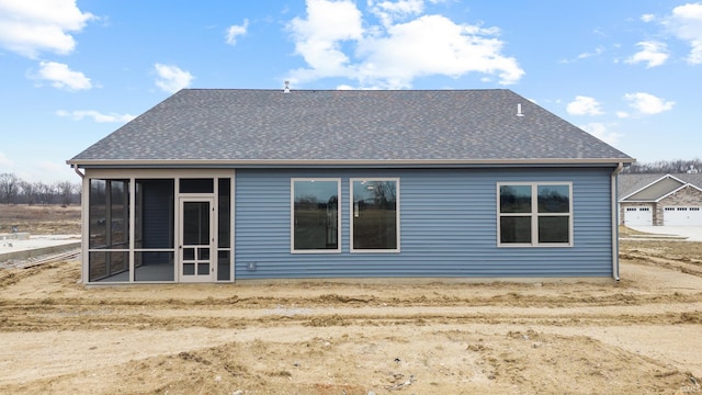 rear view of house featuring a sunroom and a shingled roof