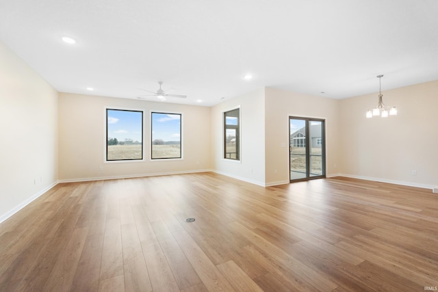 unfurnished living room featuring light wood finished floors, plenty of natural light, and baseboards