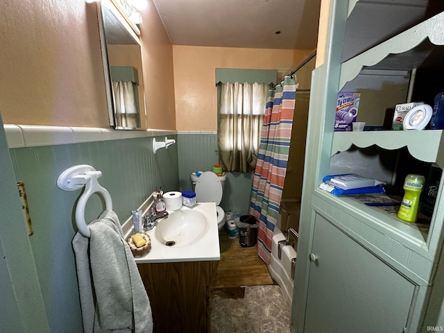 full bathroom with wainscoting, vanity, and shower / bath combo with shower curtain