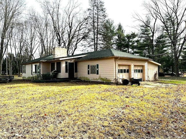 single story home with a garage, a chimney, and a front yard