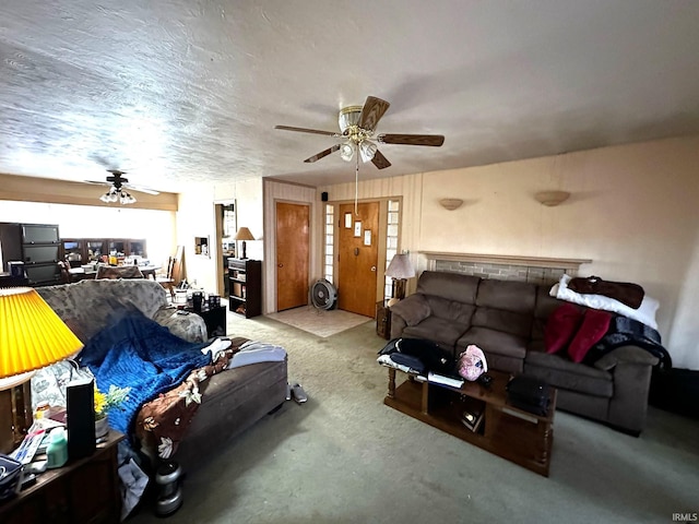 living area with light colored carpet, ceiling fan, and a textured ceiling